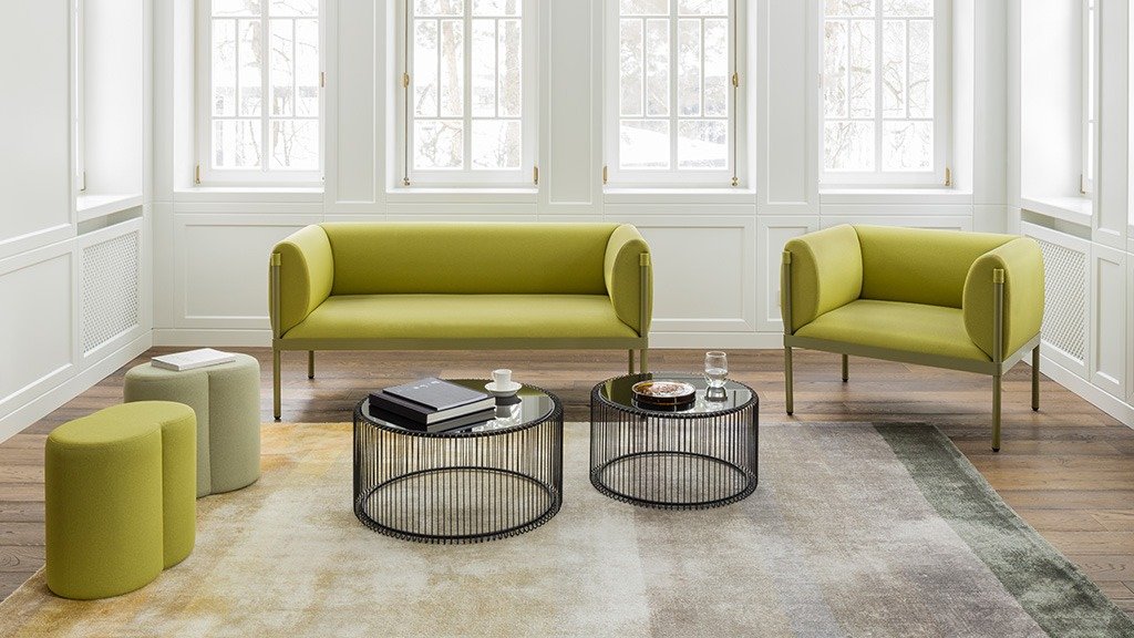 Brown leather Grace sofa on white legs in a modern interior with round table