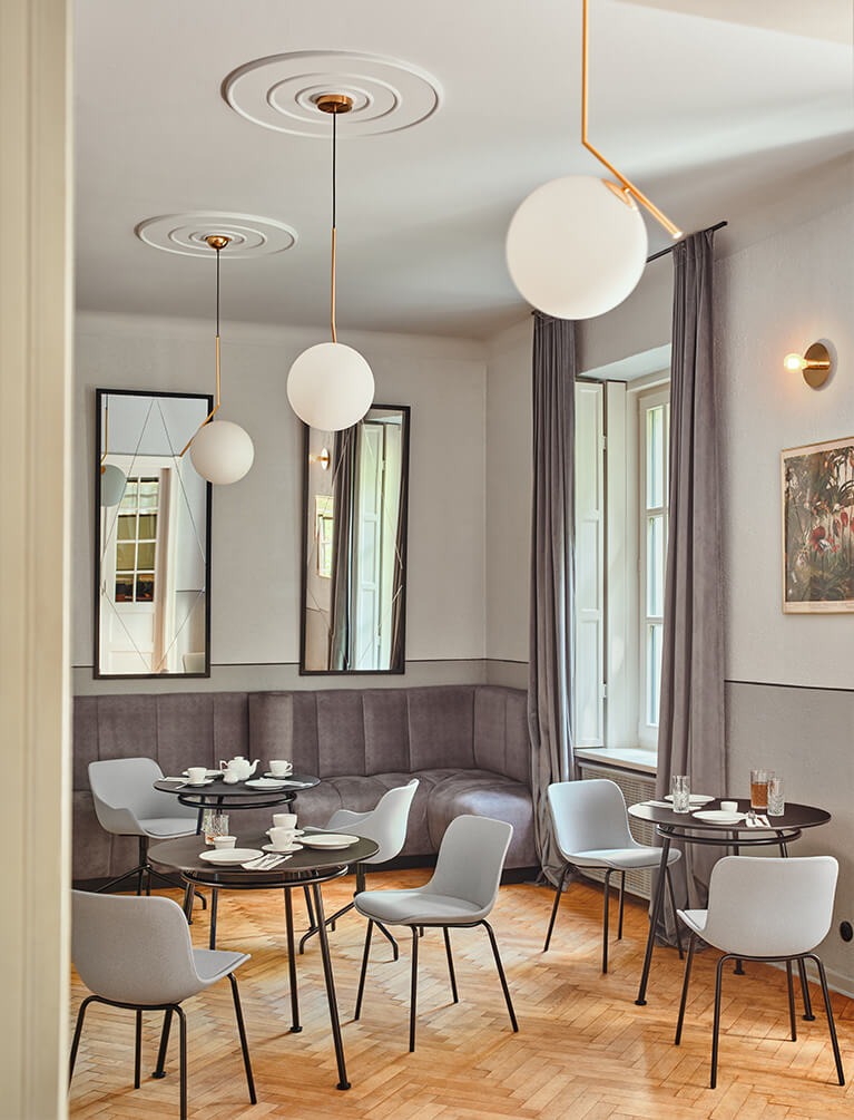 Chaises de cuisine Baltic 2 gris clair à de petites tables rondes dans une salle à manger lumineuse