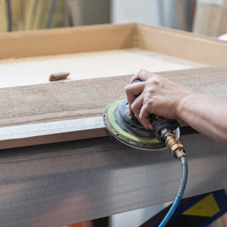 Sanding a wooden office furniture component prior to finishing