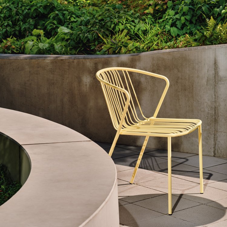 Pastel yellow Bris chair on a concrete patio