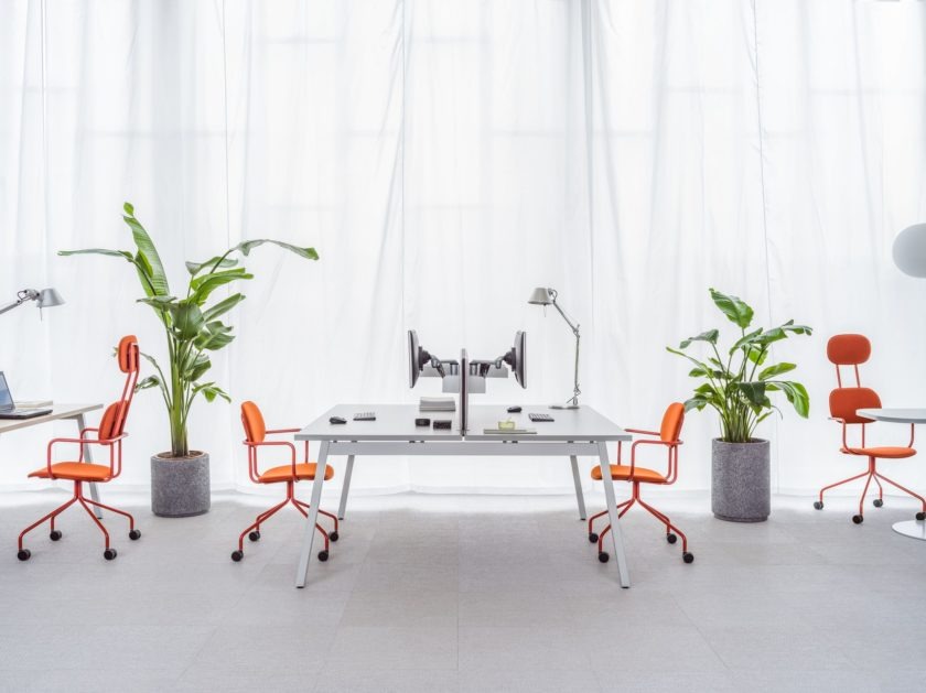 Bureau open space avec des bureaux neutres et des chaises orange