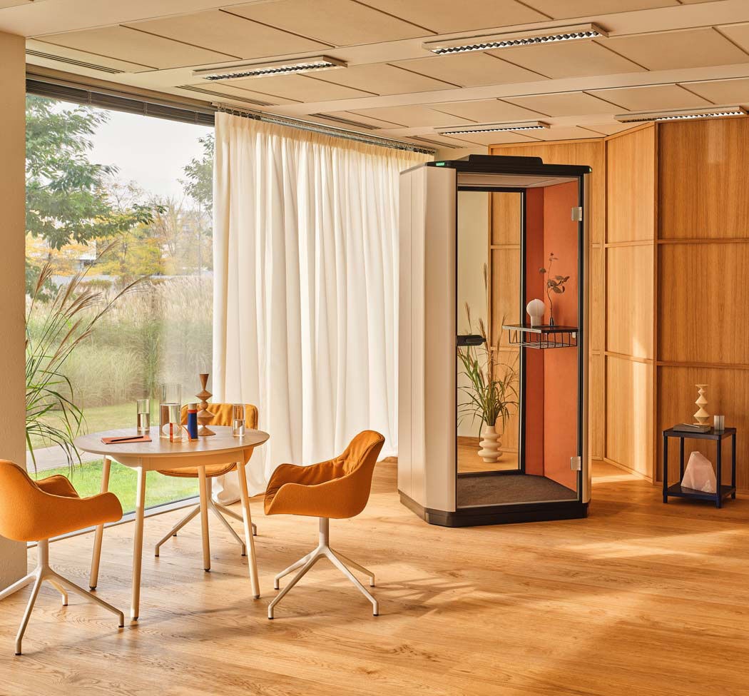 Espace lounge de bureau avec cabine acoustique, revêtu de panneaux en bois