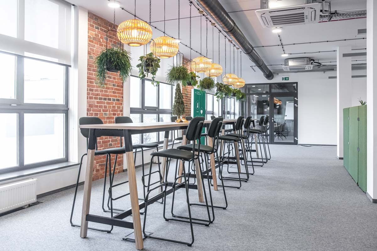 Espace de bureau équipé d'une table haute et de tabourets rembourrés