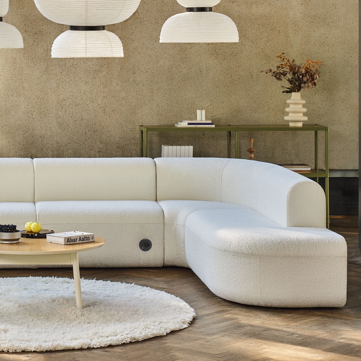 Canapé modulable Artiko avec revêtement blanc, associé à une table basse et une étagère verte