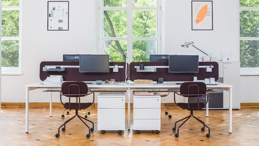 White office drawer unit with drawers placed under a workstation with a monitor