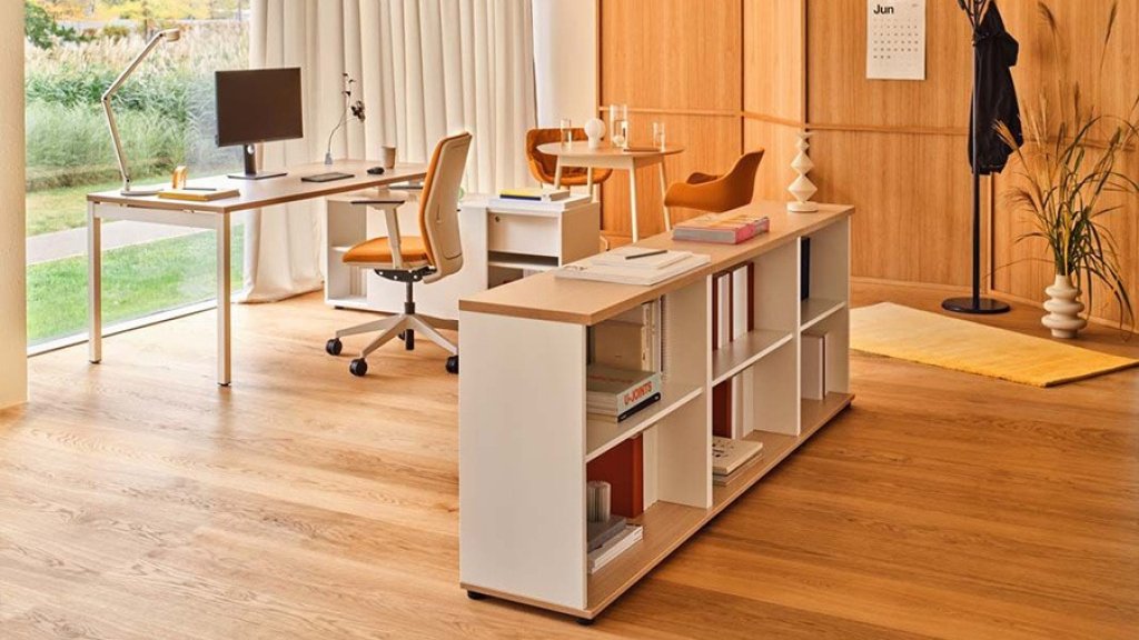 Modern office with a white desk and low bookcase in a bright interior with a wooden wall