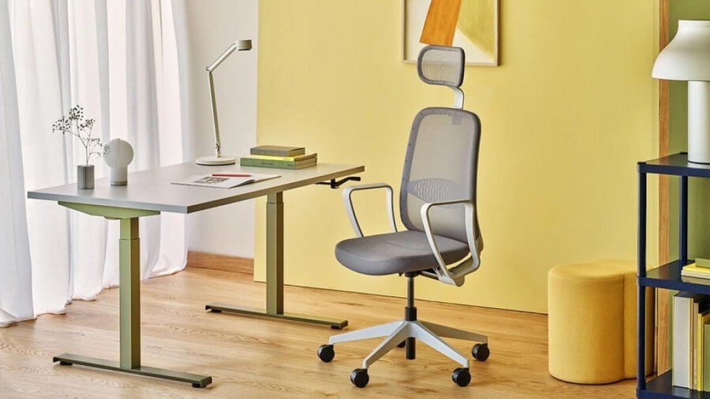 Szare krzesło biurowe Astro z zagłówkiem w kolorowej przestrzeni biurowej