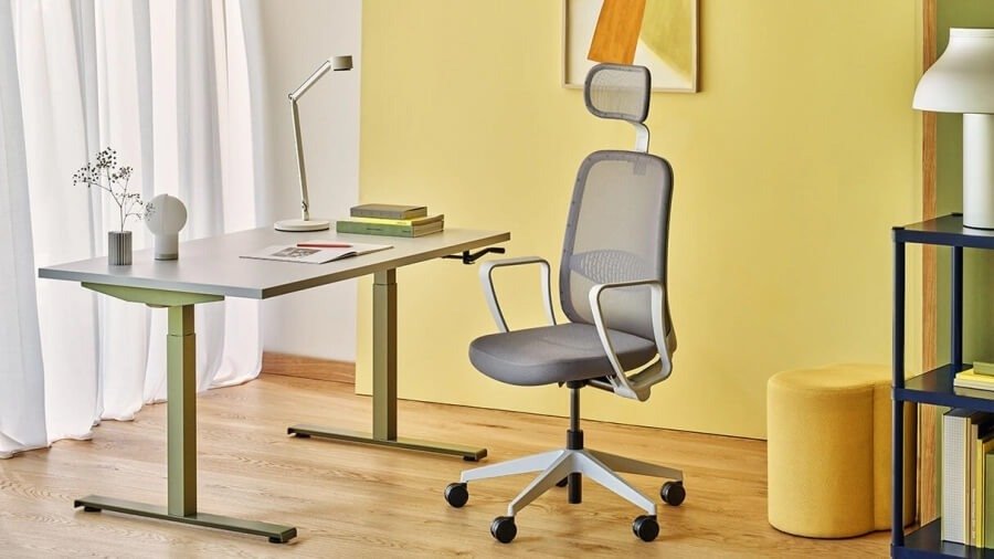 Silla de oficina Astro gris con reposacabezas en una oficina colorida
