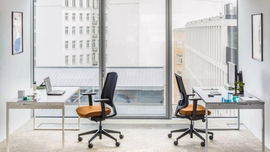 Krzesła biurowe Sava z pomarańczowymi siedziskami w dwuosobowym gabinecie