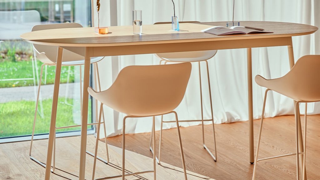 Weiße Barhocker New School mit Rückenlehne an einer abgerundeten Bartheke.