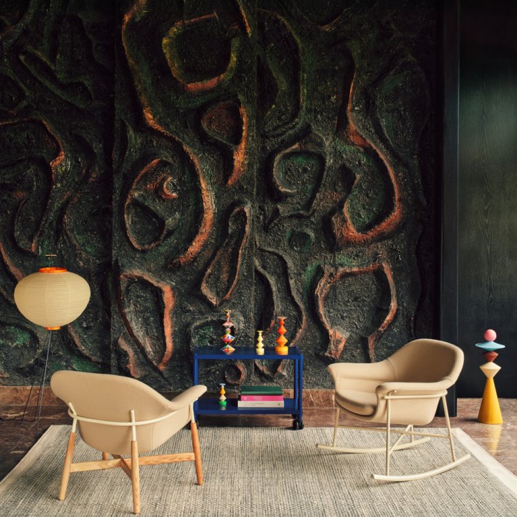 Two beige Ismo armchairs set in front of a brutalist mosaic