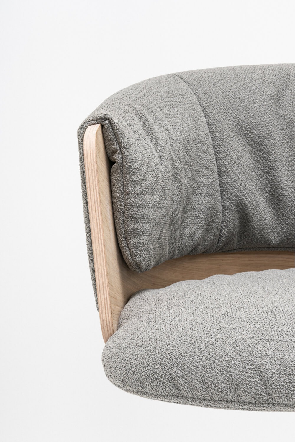 Gros plan sur le dossier du fauteuil Collar en tissu gris avec bois naturel - détails du rembourrage et finition précise d'un meuble de bureau