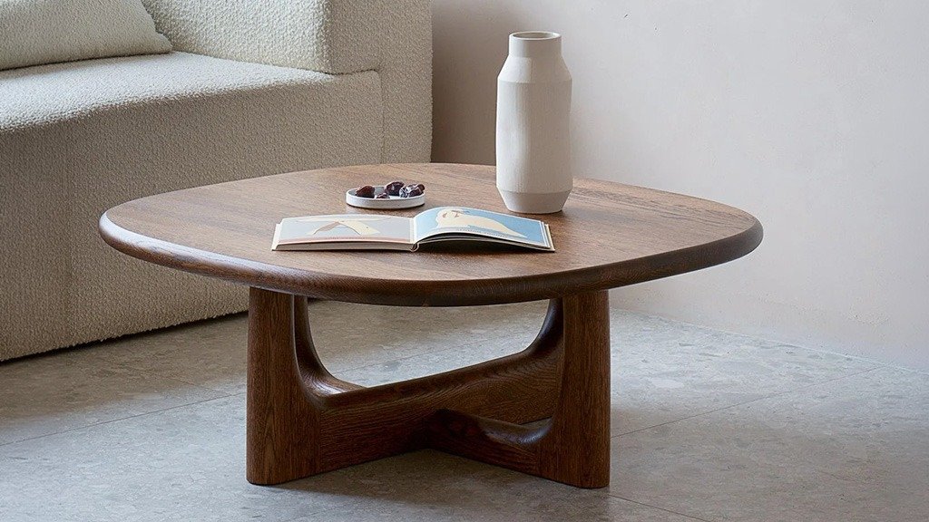 A low, wooden coffee table with a sturdy base, placed next to the sofa