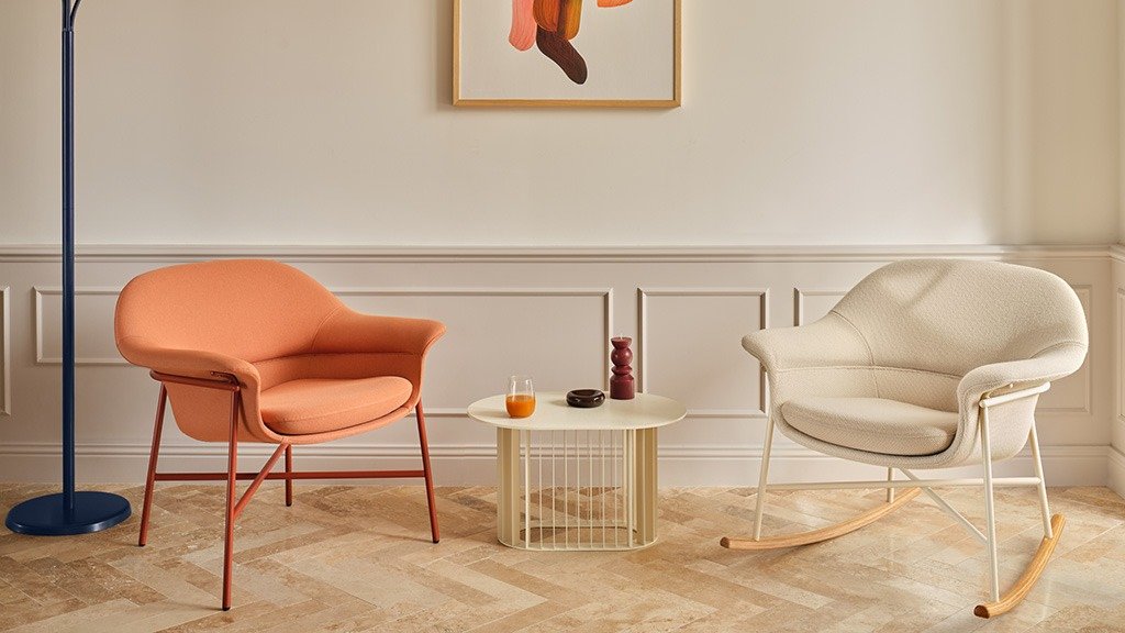 Two armchairs, one orange and one beige, and a low table in the lounge area