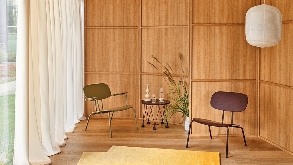 Low plywood armchairs on a metal base, arranged in a space with wooden walls